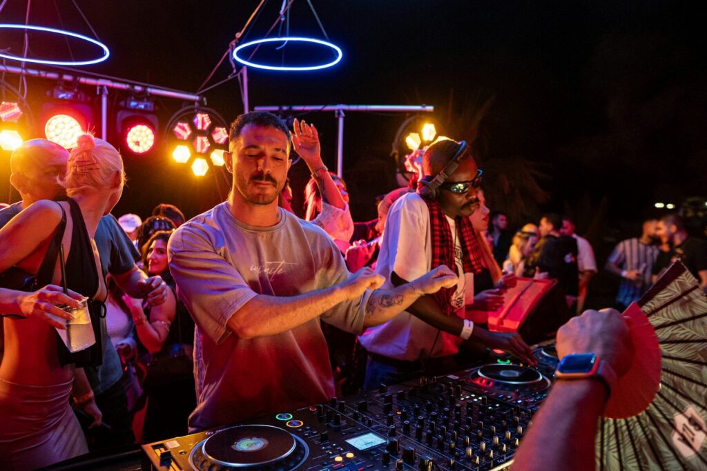 Un dj qui mix en plein ai avec des gens autour qui dansent